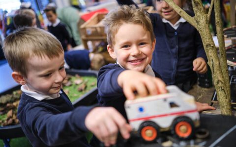 Two young boys playing with toy car